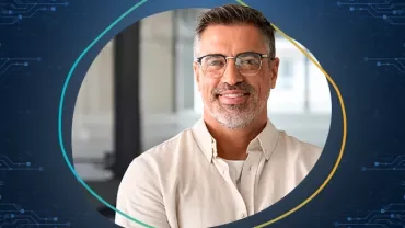 Hombre sonriente con gafas y barba en fondo tecnológico.