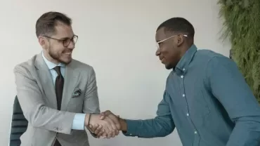 Dos hombres dándose la mano en una entrevista