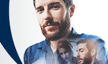 Hombre con barba y camisa azul con figuras superpuestas, fondo blanco.